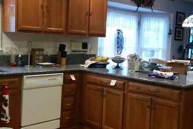 ワシントンD.C.にあるお手頃価格の中くらいなトラディショナルスタイルのおしゃれなキッチン (フラットパネル扉のキャビネット、白いキャビネット、御影石カウンター) の写真
