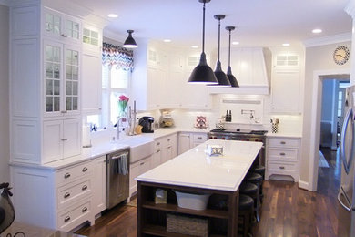 Inspiration for a large timeless l-shaped dark wood floor kitchen pantry remodel in Baltimore with a farmhouse sink, raised-panel cabinets, white cabinets, quartz countertops, white backsplash, porcelain backsplash, stainless steel appliances and an island