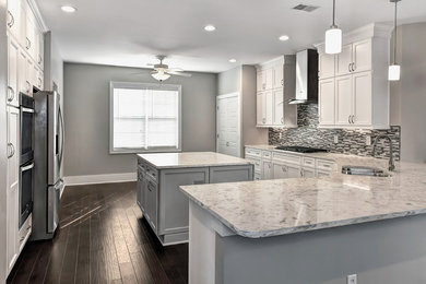 Inspiration for a large contemporary l-shaped dark wood floor and brown floor eat-in kitchen remodel in Charleston with a double-bowl sink, shaker cabinets, white cabinets, quartz countertops, multicolored backsplash, glass tile backsplash, stainless steel appliances and an island