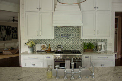 Example of a large farmhouse u-shaped medium tone wood floor and brown floor eat-in kitchen design in Charleston with a farmhouse sink, shaker cabinets, white cabinets, granite countertops, multicolored backsplash, cement tile backsplash, stainless steel appliances, an island and white countertops