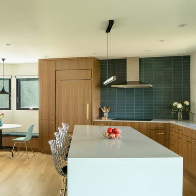 Inspiration for a large 1960s l-shaped medium tone wood floor and brown floor eat-in kitchen remodel in Portland with an undermount sink, flat-panel cabinets, medium tone wood cabinets, green backsplash, paneled appliances, an island, quartz countertops, porcelain backsplash and white countertops