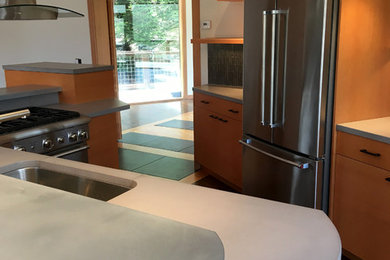 Stilmix Wohnküche in L-Form mit flächenbündigen Schrankfronten, hellen Holzschränken, Zink-Arbeitsplatte, Rückwand aus Zementfliesen, Betonboden und Kücheninsel in San Francisco