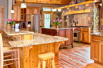 Eat-in kitchen - large rustic single-wall dark wood floor and brown floor eat-in kitchen idea in Other with stainless steel appliances, an undermount sink, raised-panel cabinets, dark wood cabinets, granite countertops, brown backsplash, ceramic backsplash and an island