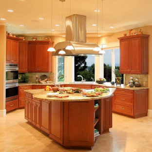 Idee per un'ampia cucina chic con elettrodomestici in acciaio inossidabile, ante con bugna sagomata, ante in legno scuro, top in granito, paraspruzzi in lastra di pietra, lavello sottopiano, pavimento in travertino, paraspruzzi giallo, pavimento giallo e top giallo