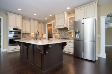 Inspiration for a mid-sized timeless l-shaped dark wood floor kitchen remodel in Other with an undermount sink, raised-panel cabinets, white cabinets, granite countertops, multicolored backsplash, glass tile backsplash, stainless steel appliances and an island