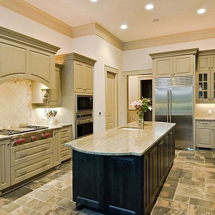 Mid-sized traditional kitchen pantry photos - Mid-sized elegant u-shaped limestone floor kitchen pantry photo in Orlando with a farmhouse sink, raised-panel cabinets, quartzite countertops, beige backsplash, ceramic backsplash, stainless steel appliances and an island