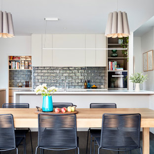 Inspiration for a large contemporary l-shaped kitchen in Melbourne with an undermount sink, flat-panel cabinets, grey splashback, stainless steel appliances, multiple islands, brown floor and white benchtop.