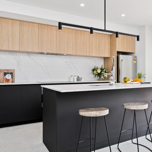 Photo of a mid-sized scandinavian galley kitchen in Perth with an undermount sink, flat-panel cabinets, black cabinets, white splashback, stainless steel appliances, porcelain floors, with island, grey floor and white benchtop.
