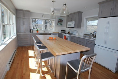 Inspiration for a large transitional l-shaped light wood floor eat-in kitchen remodel in Boston with a farmhouse sink, recessed-panel cabinets, gray cabinets, granite countertops, white backsplash and an island