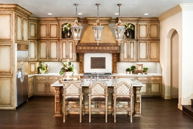 Inspiration for a mid-sized timeless u-shaped dark wood floor and brown floor eat-in kitchen remodel in Dallas with an undermount sink, distressed cabinets, white backsplash, stainless steel appliances, an island, white countertops, raised-panel cabinets, granite countertops and glass sheet backsplash