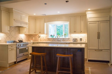 Bild på ett mellanstort vintage l-kök, med en undermonterad diskho, integrerade vitvaror, mellanmörkt trägolv, brunt golv, luckor med infälld panel, beige skåp, bänkskiva i koppar och en köksö