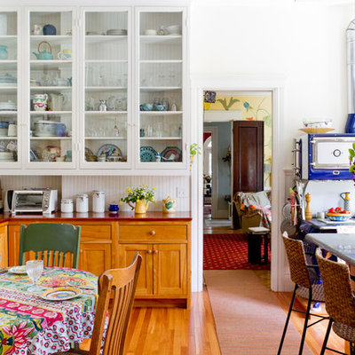 Example of an eclectic eat-in kitchen design in Boston with wood countertops, glass-front cabinets, white cabinets, multicolored backsplash and colored appliances
