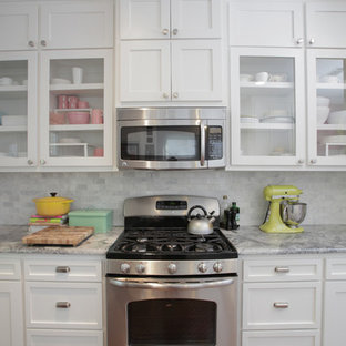 This is an example of an eclectic kitchen in Dallas with granite benchtops, shaker cabinets, white cabinets, white splashback, stone tile splashback and stainless steel appliances.