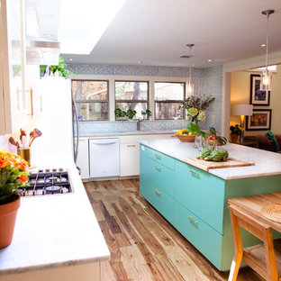 This is an example of an eclectic l-shaped kitchen in Austin with flat-panel cabinets, blue cabinets, marble benchtops and white appliances.