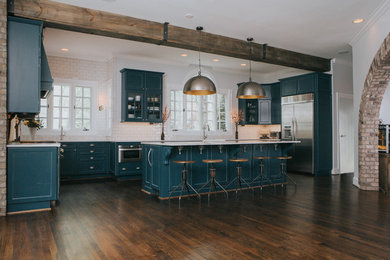 Eat-in kitchen - large eclectic u-shaped dark wood floor and brown floor eat-in kitchen idea in Charlotte with a farmhouse sink, flat-panel cabinets, blue cabinets, marble countertops, white backsplash, ceramic backsplash, stainless steel appliances and an island