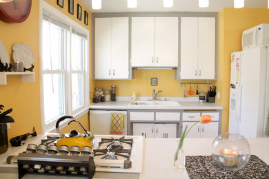 Cette image montre une cuisine bohème en U avec des portes de placard blanches, un évier posé et un électroménager blanc.