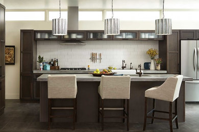 Example of a large minimalist single-wall concrete floor and gray floor eat-in kitchen design in Atlanta with a farmhouse sink, shaker cabinets, dark wood cabinets, concrete countertops, white backsplash, subway tile backsplash, stainless steel appliances, an island and gray countertops