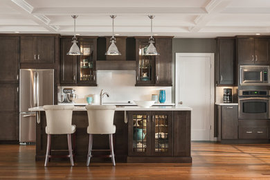 Eat-in kitchen - mid-sized transitional single-wall medium tone wood floor eat-in kitchen idea in Other with a drop-in sink, dark wood cabinets, white backsplash, stainless steel appliances, an island, shaker cabinets, solid surface countertops and subway tile backsplash