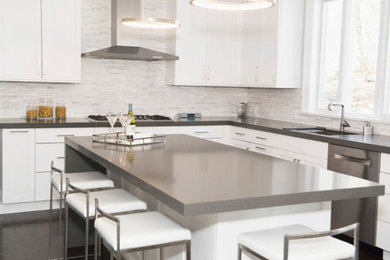 Inspiration for a large modern u-shaped dark wood floor eat-in kitchen remodel in New York with an undermount sink, recessed-panel cabinets, white cabinets, white backsplash, stainless steel appliances and an island