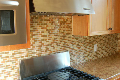 Exemple d'une cuisine en bois clair avec un électroménager en acier inoxydable, un plan de travail en granite et une crédence en mosaïque.