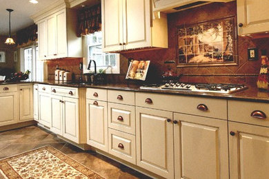 Example of a mid-sized classic u-shaped ceramic tile open concept kitchen design in New York with an undermount sink, raised-panel cabinets, white cabinets, granite countertops, brown backsplash, terra-cotta backsplash, a peninsula and paneled appliances