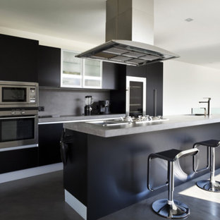 Design ideas for a large modern single-wall eat-in kitchen in Other with a drop-in sink, flat-panel cabinets, black cabinets, granite benchtops, black splashback, stainless steel appliances, with island, black floor, grey benchtop, slate splashback and ceramic floors.