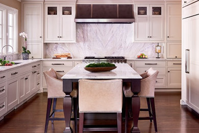 Mid-sized transitional u-shaped dark wood floor and brown floor enclosed kitchen photo in Charlotte with shaker cabinets, white cabinets, marble countertops, gray backsplash, marble backsplash, paneled appliances and an island