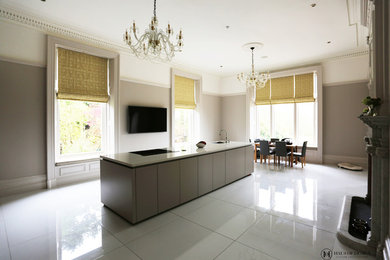 Photo of a large modern single-wall open plan kitchen in Other with a submerged sink, flat-panel cabinets, grey cabinets, composite countertops, black appliances, porcelain flooring, an island, white floors and white worktops.