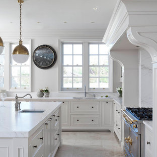 Immagine di una grande cucina chic con lavello da incasso, ante a filo, ante bianche, top in marmo, paraspruzzi bianco, paraspruzzi in marmo, elettrodomestici in acciaio inossidabile, pavimento in gres porcellanato, isola, pavimento beige e top giallo