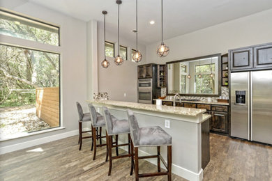 Enclosed kitchen - mid-sized transitional galley vinyl floor and multicolored floor enclosed kitchen idea in Austin with a single-bowl sink, raised-panel cabinets, dark wood cabinets, granite countertops, multicolored backsplash, glass tile backsplash, stainless steel appliances and no island