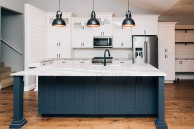 Inspiration for a cottage kitchen remodel in Boise with shaker cabinets, white cabinets and an island