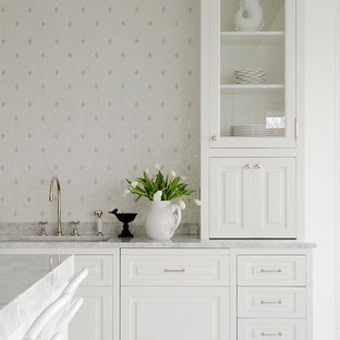 Beach style kitchen in New York with white cabinets and with island.