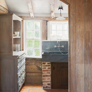 This is an example of a small country u-shaped separate kitchen in Providence with a farmhouse sink, open cabinets, distressed cabinets, soapstone benchtops, blue splashback, stone slab splashback, coloured appliances, medium hardwood floors and no island.