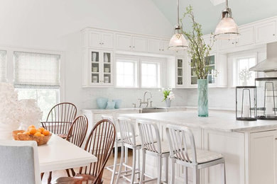 Inspiration for a transitional eat-in kitchen remodel in Boston with a farmhouse sink, glass-front cabinets, white cabinets and white backsplash
