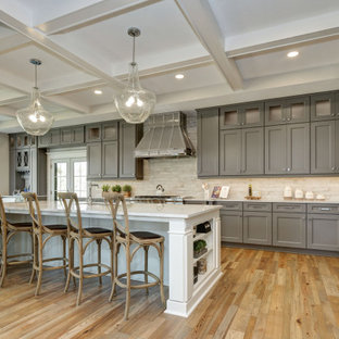 Large traditional eat-in kitchen inspiration - Example of a large classic l-shaped medium tone wood floor and beige floor eat-in kitchen design in Other with an undermount sink, shaker cabinets, gray cabinets, beige backsplash, stainless steel appliances, an island and white countertops
