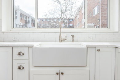 Small country u-shaped enclosed kitchen photo in New York with a farmhouse sink, shaker cabinets, white cabinets, quartz countertops, white backsplash, subway tile backsplash and stainless steel appliances