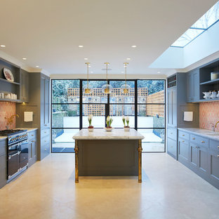 Photo of a large transitional kitchen in London with blue cabinets, red splashback and with island.