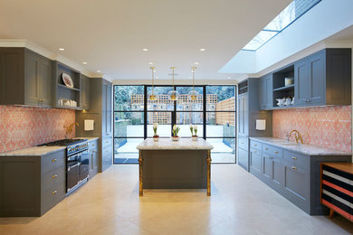 Photo of a large traditional kitchen in London with blue cabinets, red splashback and an island.