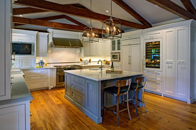 Large cottage u-shaped light wood floor eat-in kitchen photo in San Francisco with a farmhouse sink, beaded inset cabinets, white cabinets, marble countertops, white backsplash, subway tile backsplash, stainless steel appliances and an island