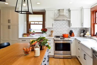 Kitchen - cottage kitchen idea in Boston with a farmhouse sink, shaker cabinets, white cabinets, quartz countertops, white backsplash, subway tile backsplash and stainless steel appliances