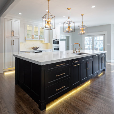 Large transitional u-shaped dark wood floor and brown floor kitchen photo in Other with an undermount sink, flat-panel cabinets, white cabinets, quartz countertops, white backsplash, stone slab backsplash, stainless steel appliances, an island and white countertops