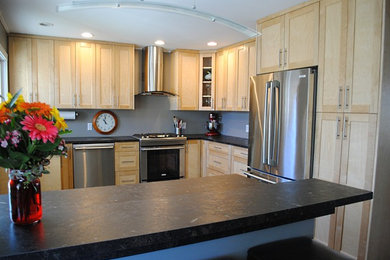 Example of a large trendy u-shaped eat-in kitchen design in Vancouver with shaker cabinets, light wood cabinets, laminate countertops, stainless steel appliances and a peninsula
