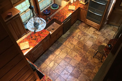 Example of a mid-sized farmhouse u-shaped limestone floor eat-in kitchen design in Other with a farmhouse sink, raised-panel cabinets, medium tone wood cabinets, copper countertops, beige backsplash, stone tile backsplash, stainless steel appliances and a peninsula