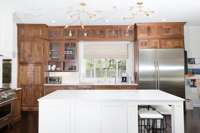 Inspiration for a large craftsman l-shaped dark wood floor open concept kitchen remodel in Dallas with an undermount sink, shaker cabinets, medium tone wood cabinets, quartz countertops, white backsplash and an island