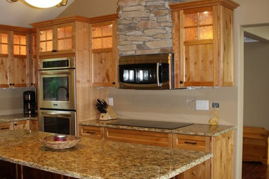 Foto på ett rustikt kök, med skåp i mörkt trä, granitbänkskiva, rostfria vitvaror och en köksö