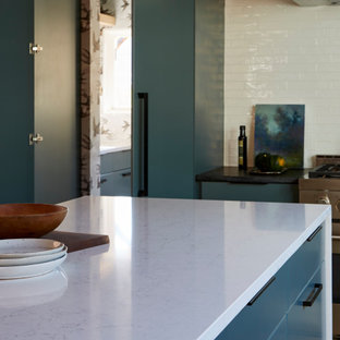 Modern eat-in kitchen designs - Inspiration for a modern single-wall eat-in kitchen remodel in Austin with flat-panel cabinets, quartz countertops, white backsplash, stainless steel appliances, no island and black countertops