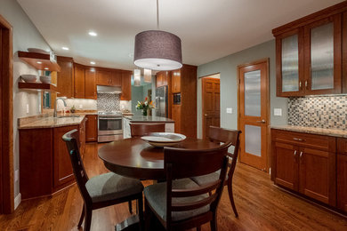 Example of a large transitional l-shaped medium tone wood floor eat-in kitchen design in Minneapolis with an undermount sink, recessed-panel cabinets, medium tone wood cabinets, granite countertops, gray backsplash, ceramic backsplash, stainless steel appliances and an island
