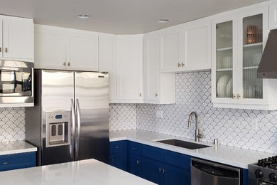 Mid-sized transitional u-shaped cement tile floor and gray floor kitchen photo in San Diego with an undermount sink, shaker cabinets, blue cabinets, quartz countertops, white backsplash, ceramic backsplash, stainless steel appliances, an island and white countertops