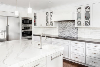 Inspiration for a mid-sized timeless u-shaped dark wood floor and brown floor enclosed kitchen remodel in Raleigh with an undermount sink, shaker cabinets, gray cabinets, marble countertops, white backsplash, subway tile backsplash, stainless steel appliances, an island and gray countertops