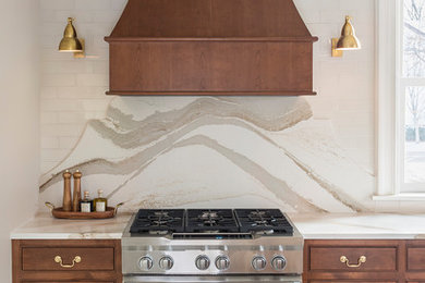 Example of a mid-sized classic l-shaped porcelain tile and beige floor enclosed kitchen design in Minneapolis with an undermount sink, beaded inset cabinets, medium tone wood cabinets, quartz countertops, multicolored backsplash, stone slab backsplash, paneled appliances, an island and multicolored countertops